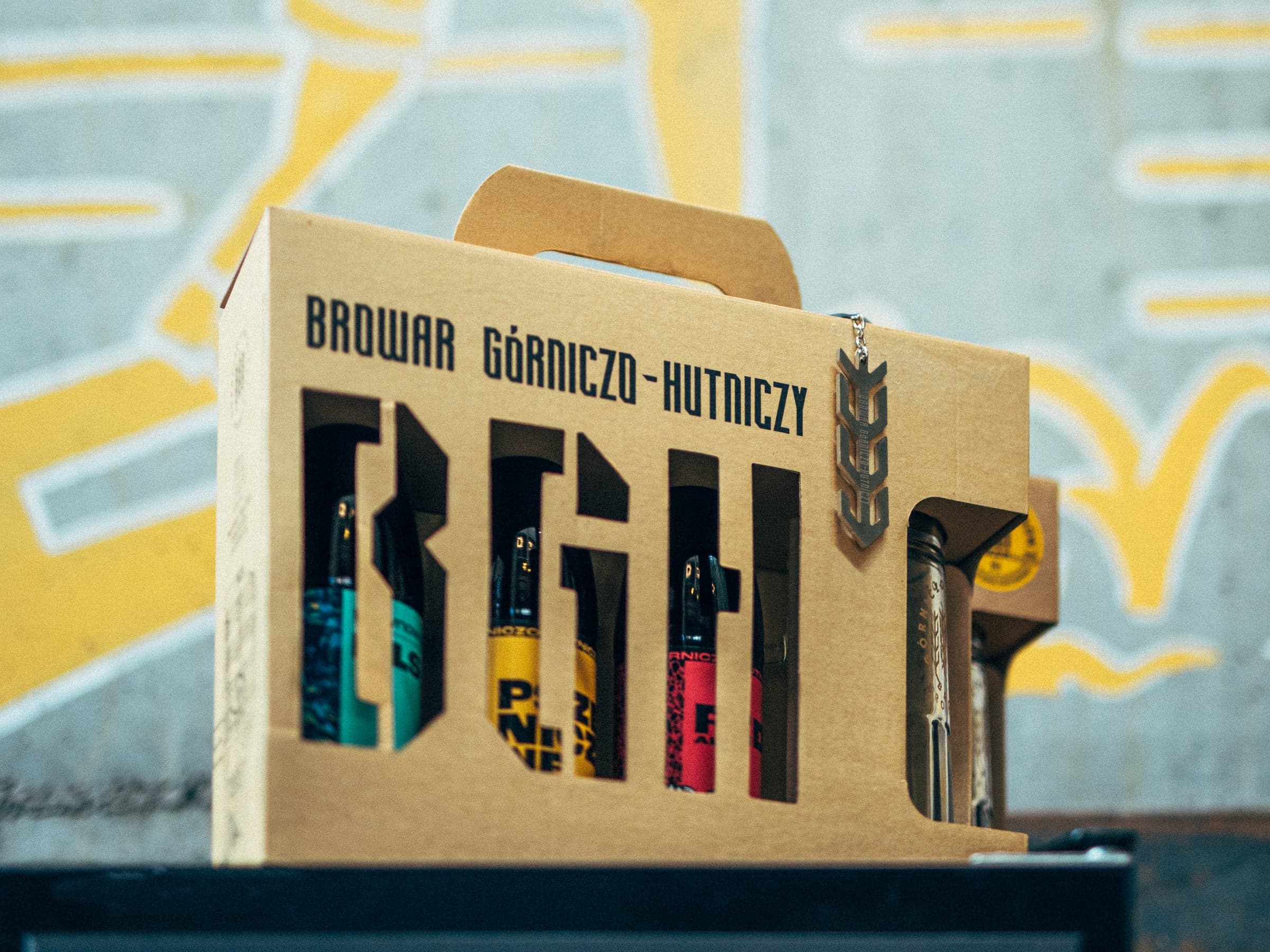 A BGH three-pack with a mug in a cardboard gift box, a yellow mural behind