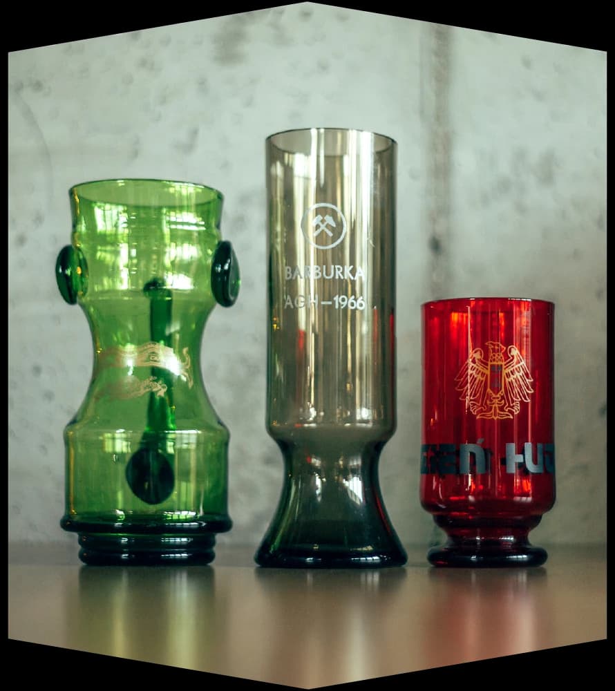Three vintage AGH glasses — green, smoked with the “Barbórka AGH 1966” engraving, and red with an eagle
