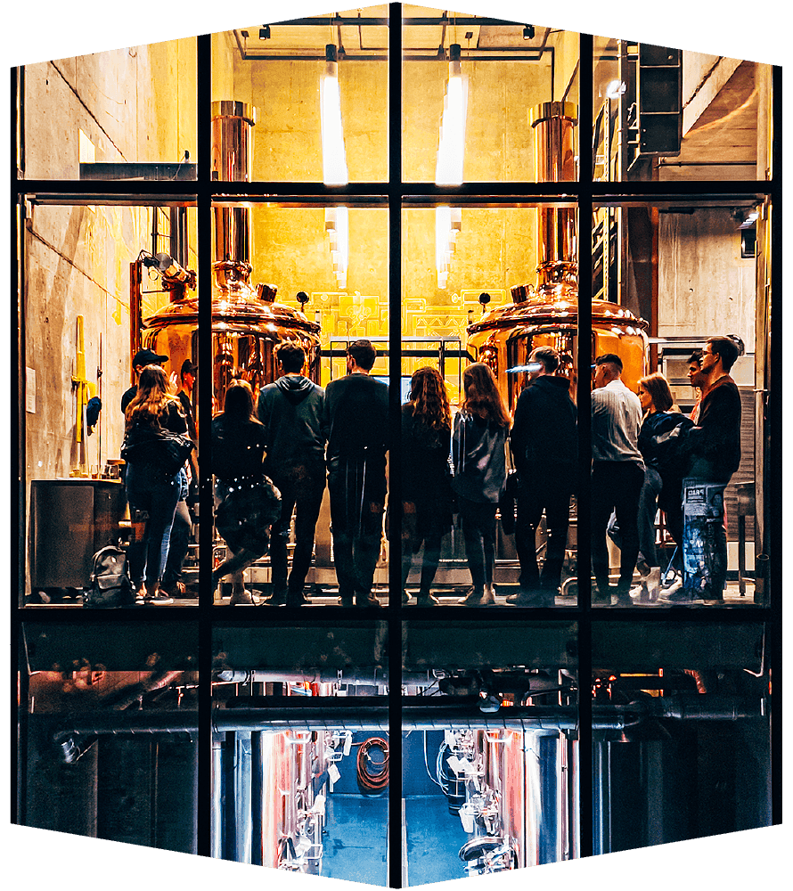 A tour group beside the copper brewhouse vessels at BGH