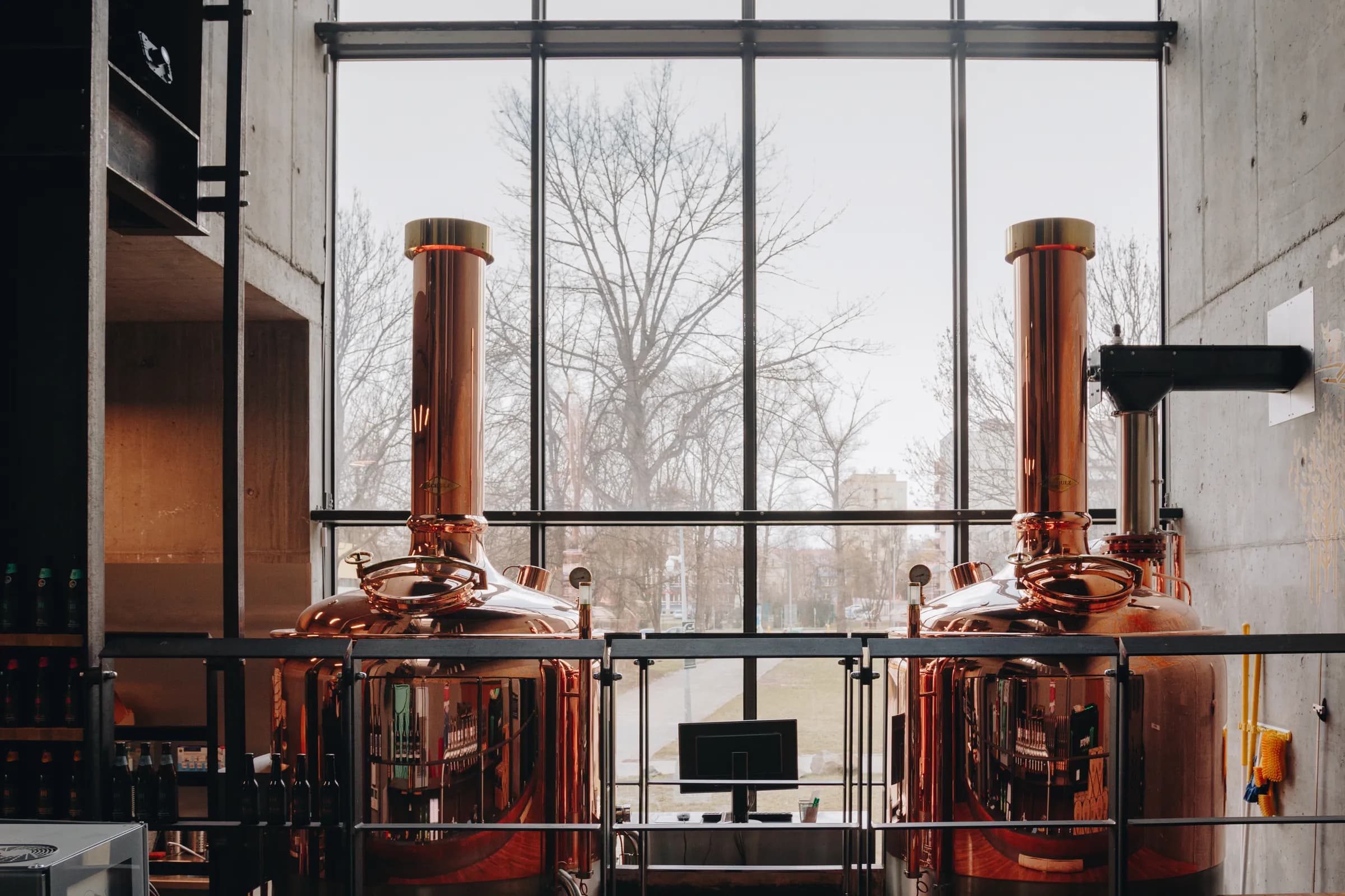 Two copper vessels of the Kaspar Schulz brewhouse in front of the glazed wall of the hall