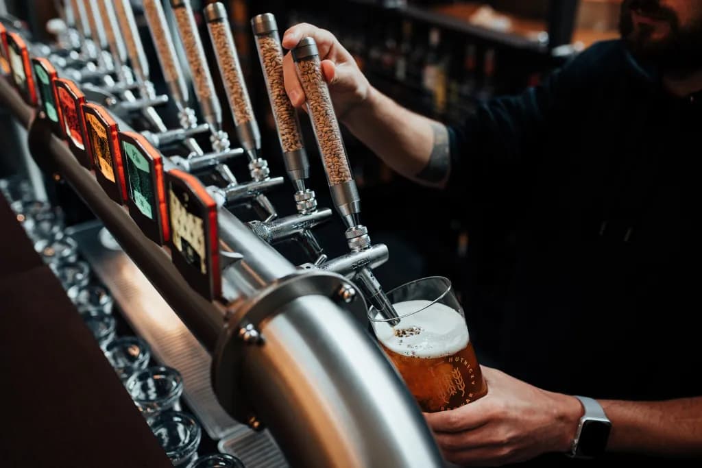 A bartender pouring beer from the tap bank at the BGH bar
